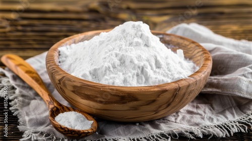 Heap of white baking powder in wooden bowl on rustic table
