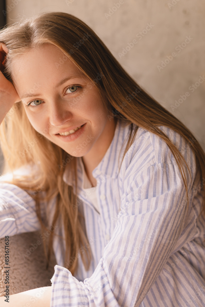 Portrait of blonde woman posing for portrait at home, sitting on comfortable armchair, looking with smile, laughing, leaning head on hand. Girl look sensual and dreaming wear shirt Portrait of blonde woman posing for portrait at home, sitting on comfortable armchair, looking with smile, laughing, leaning head on hand. Girl look sensual and dreaming wear shirt