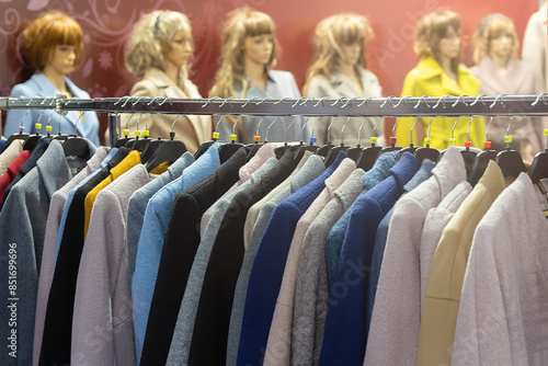 Multi-colored women's coats on hangers and mannequins in the store