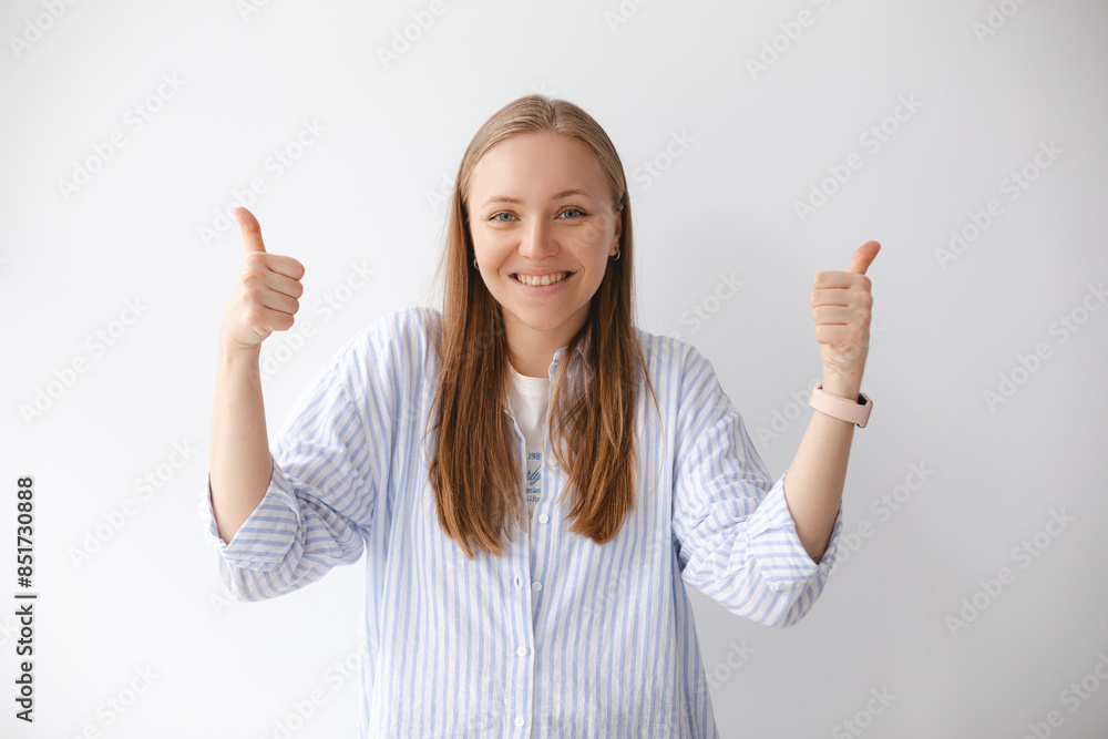 Portrait of confident blonde woman in shirt showing thumb up in approval, recommending, like something good, standing over white background wall. Portrait of confident blonde woman in shirt showing thumb up in approval, recommending, like something good, standing over white background wall.
