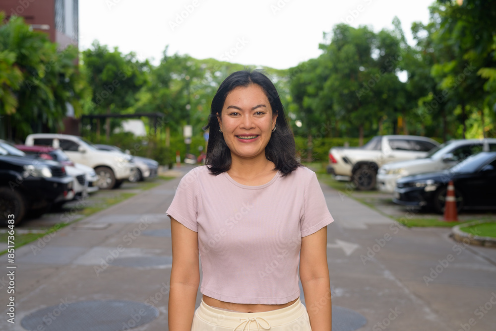 Fototapeta premium Portrait of beautiful Asian woman outdoor in parking lot during summer