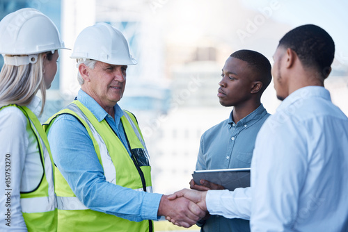 Building, handshake and men in deal for architecture, planning and agreement at construction site. Project, collaboration and civil engineering team shaking hands for urban development with welcome photo