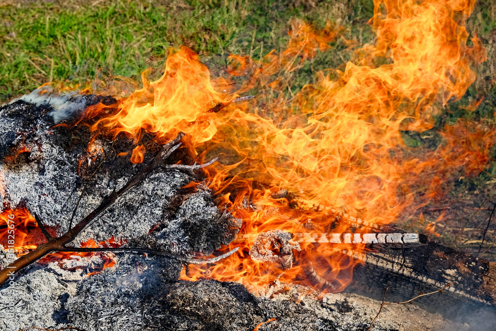 The fire is burning in a pile of what appears to be garden waste. The fire is burning in a pile of what appears to be garden waste.