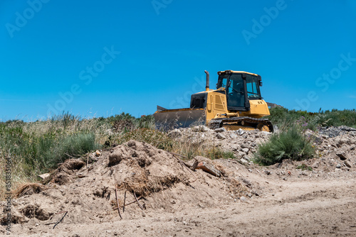 Máquina de rastos em ação num solo pedregoso na construção de uma nova estrada