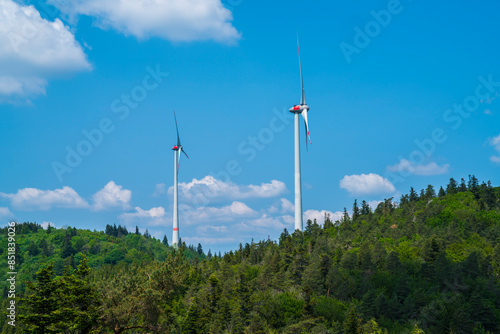 Obraz na płótnie Germany, Two giant wind turbines in green woodland of black forest schwarzwald nature landscape generating electricity w salonie