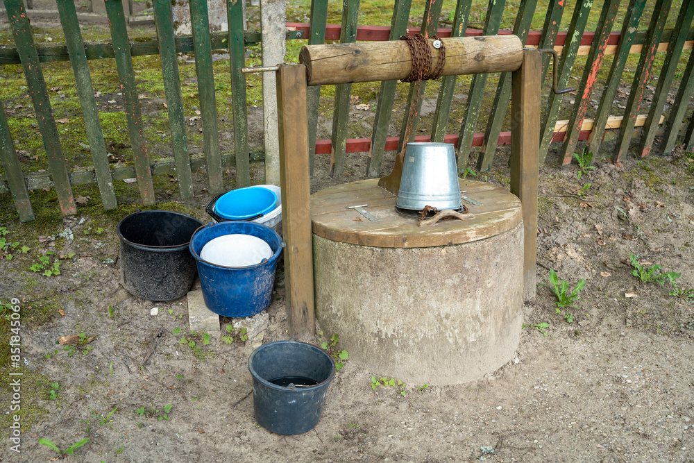 Metal and plastic water buckets on old draw well Metal and plastic water buckets on old draw well