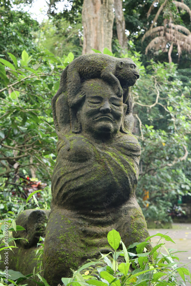 Stone statue with an monkey on a human head Stone statue with an monkey on a human head