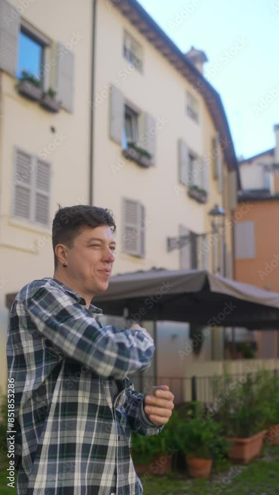 A man is stretching outdoors in a European courtyard, amidst urban architecture and vegetation A man is stretching outdoors in a European courtyard, amidst urban architecture and vegetation