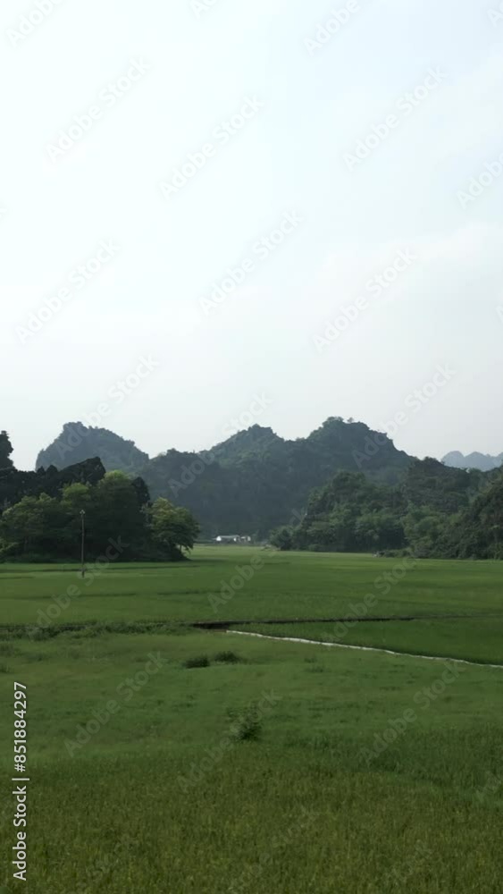 Drone flying over the green crop fields among the forested mountains of Hanoi Vietnam on a gray day Drone flying over the green crop fields among the forested mountains of Hanoi Vietnam on a gray day