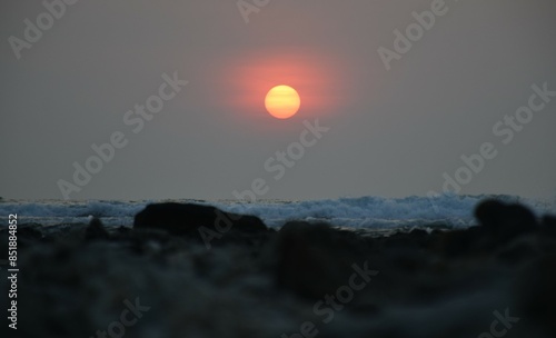 sunset over the sea with white wave and wild rock .orange sun with sea scape  at  khaolak  thailand photo