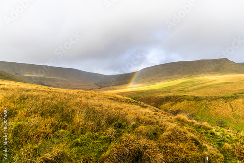 Rainbow during rain in Brecon Beacons Blaen y Glyn Isaf and Gwaun Cerrig Llwydion area during autumn photo