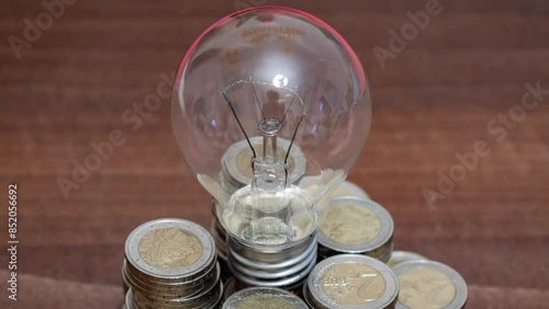 Lamp among coins. Rising electricity prices and blackout in Ukraine due to war