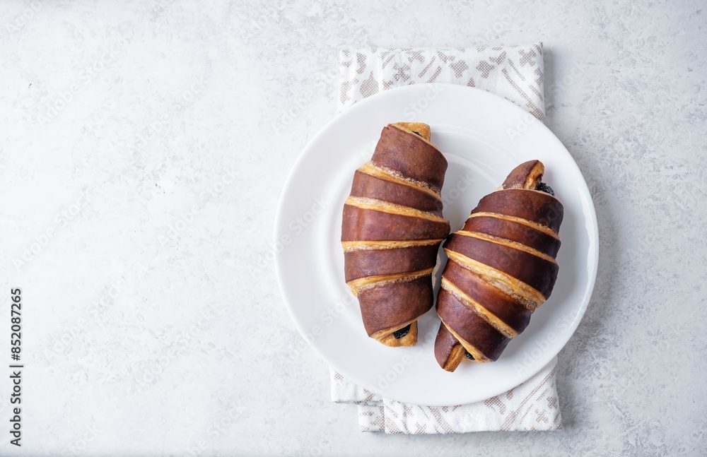 Obraz na plátně Chocolate croissants with chocolate glaze in a plate