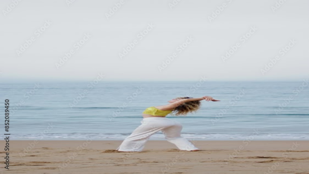 Flexible girl dancer bending body performing dance on evening sea coast vertical Flexible girl dancer bending body performing dance on evening sea coast vertical