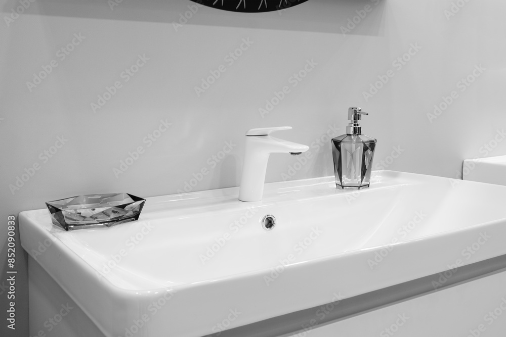 Fototapeta premium A sink with a soap dispenser and a small dish on top of it
