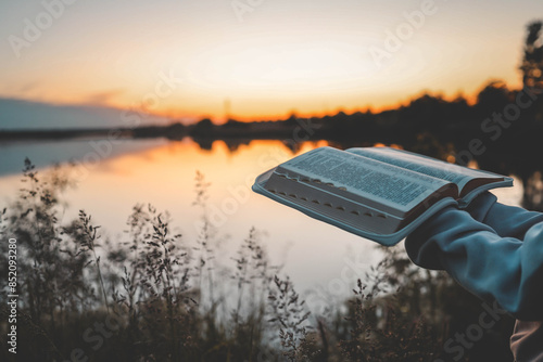 Obraz na płótnie Woman hands holding bible and reading at river in the morning