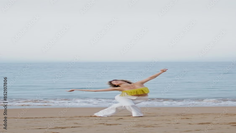 Woman moving body gracefully on sand beach evening vertical. Curly girl dancing Woman moving body gracefully on sand beach evening vertical. Curly girl dancing