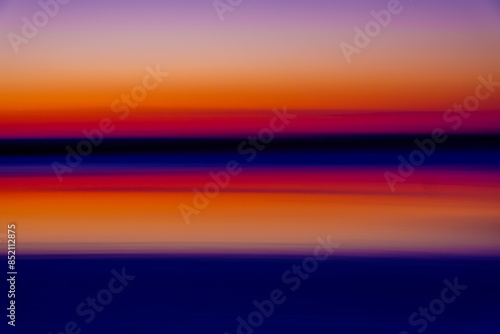 A stunning abstract image of a sunset over the sea with vibrant orange, purple, and blue hues creating a serene and peaceful atmosphere.