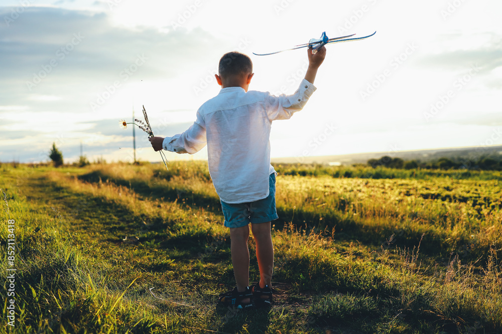 Child on a field at sunset, happy childhood
