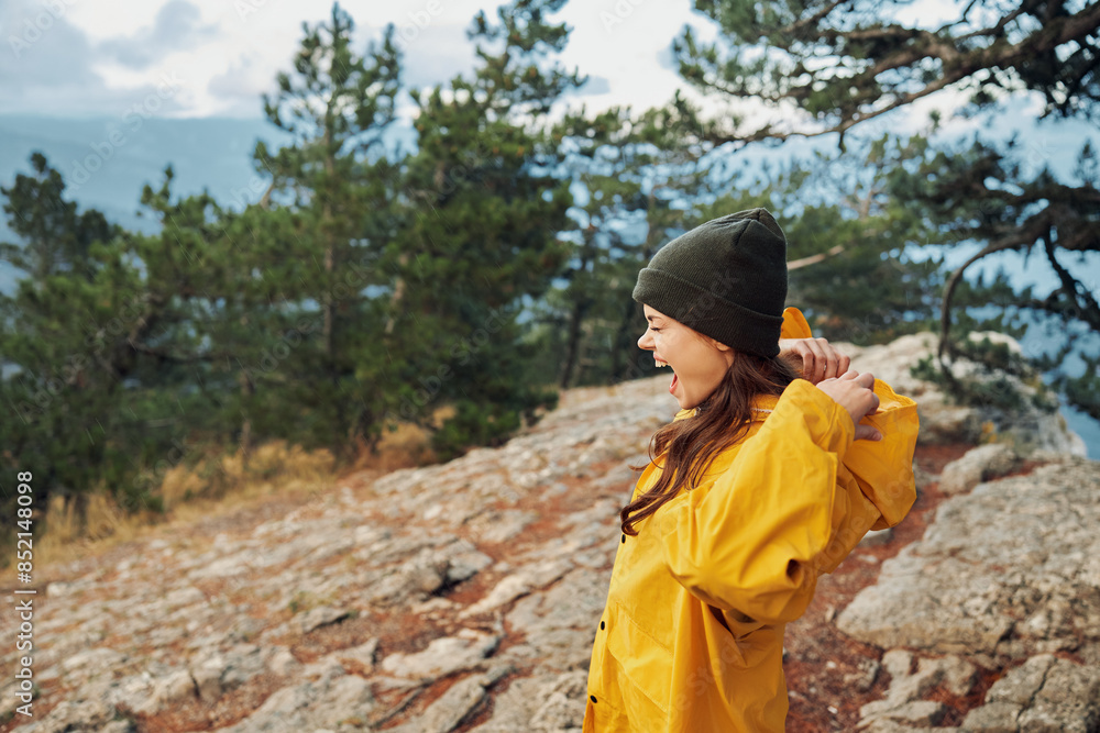 A woman in a vibrant yellow raincoat enjoying stunning mountain views surrounded by nature and adventure A woman in a vibrant yellow raincoat enjoying stunning mountain views surrounded by nature and adventure