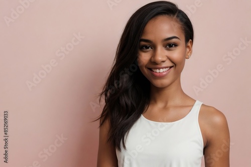 Attractive black girl wearing a cropped tank top standing against a pink background with copy space.