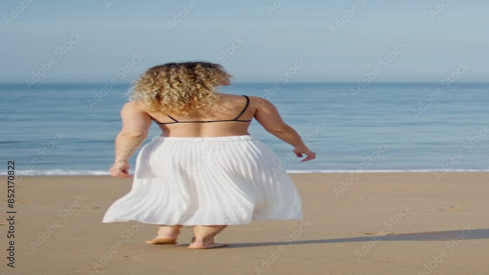 Relaxed girl stepping sand beach relaxing at evening sunlight back view vertical Relaxed girl stepping sand beach relaxing at evening sunlight back view vertical