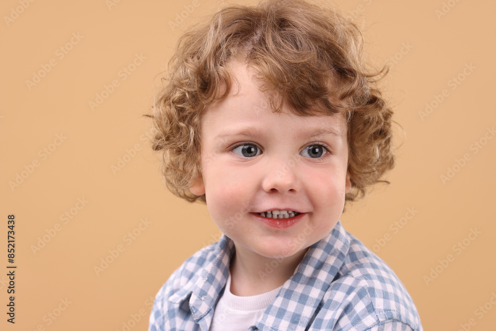Portrait of cute little boy on beige background Portrait of cute little boy on beige background