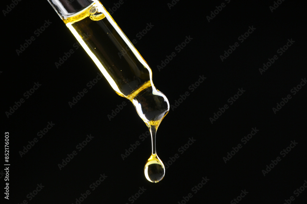 Dripping tincture from pipette on black background, closeup. Space for text Dripping tincture from pipette on black background, closeup. Space for text
