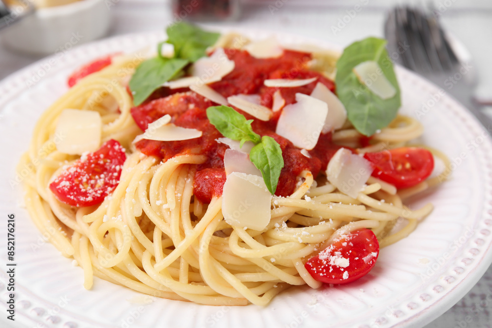Tasty pasta with tomato sauce, cheese and basil on white table, closeup Tasty pasta with tomato sauce, cheese and basil on white table, closeup