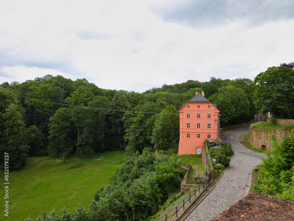Fototapeta premium Blick von Schloss Colditz auf das markante rosa gefärbte Beamtenhaus und die umliegende Parklandschaft am 31. Mai 2024, historisches Ensemble im Landkreis Leipzig, Sachsen, Deutschland