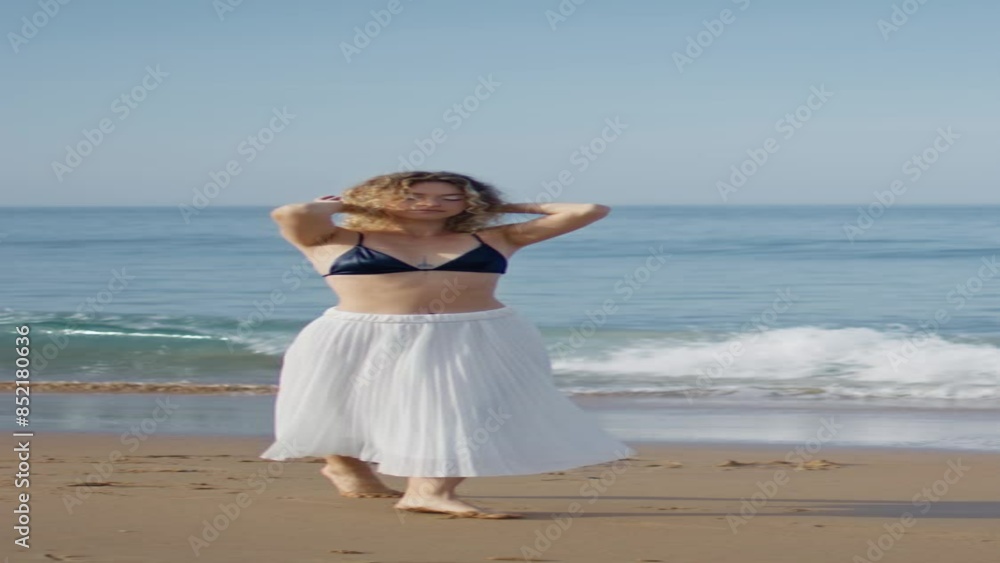 Dancer woman raising hands walking beach vertical. Performer moving gracefully Dancer woman raising hands walking beach vertical. Performer moving gracefully