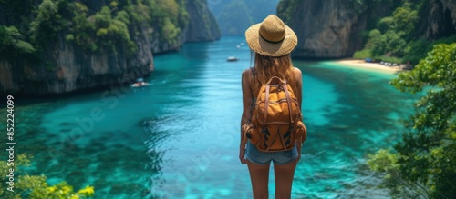 Female traveler in hiking boots with a backpack and a hat explores nature. A woman stands on the beach
