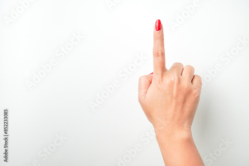 Raised woman's hand with bright red nail polish is making a pointing or touching gesture. Isolated on white background - Cut Out