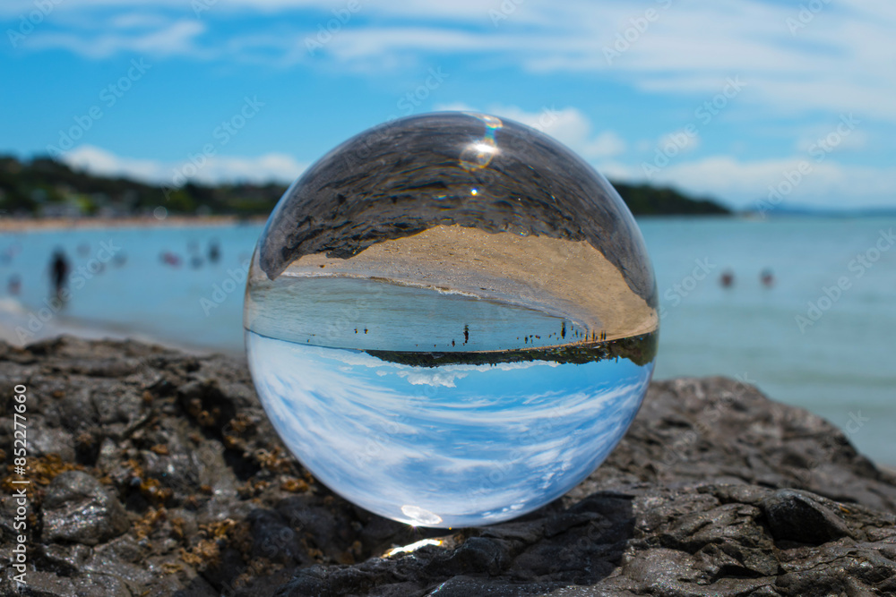 Glass Ball on the Rock, at the background is Panoramic View of Maraetai Beach Auckland, New Zealand