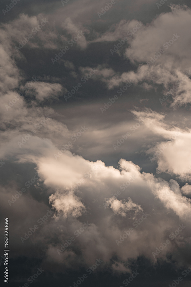 Clouds catching the sunlight with a dramatic dark storm in the background Clouds catching the sunlight with a dramatic dark storm in the background