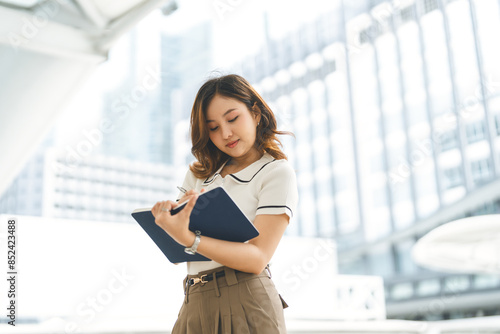Free Download Portrait business woman writing journal note city building background - GFXLoad
