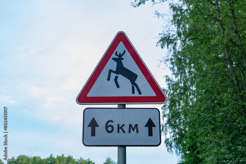 Warning road sign deer about the movement of wild animals