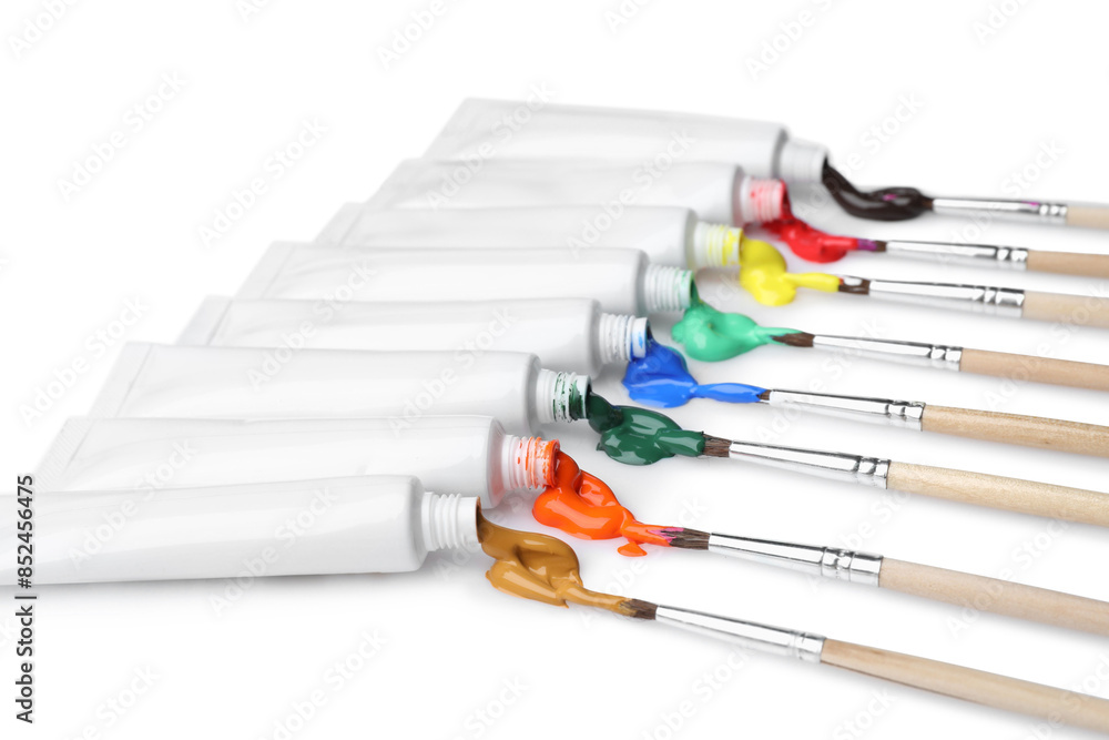 Fototapeta premium Tubes with colorful paints and brushes isolated on white