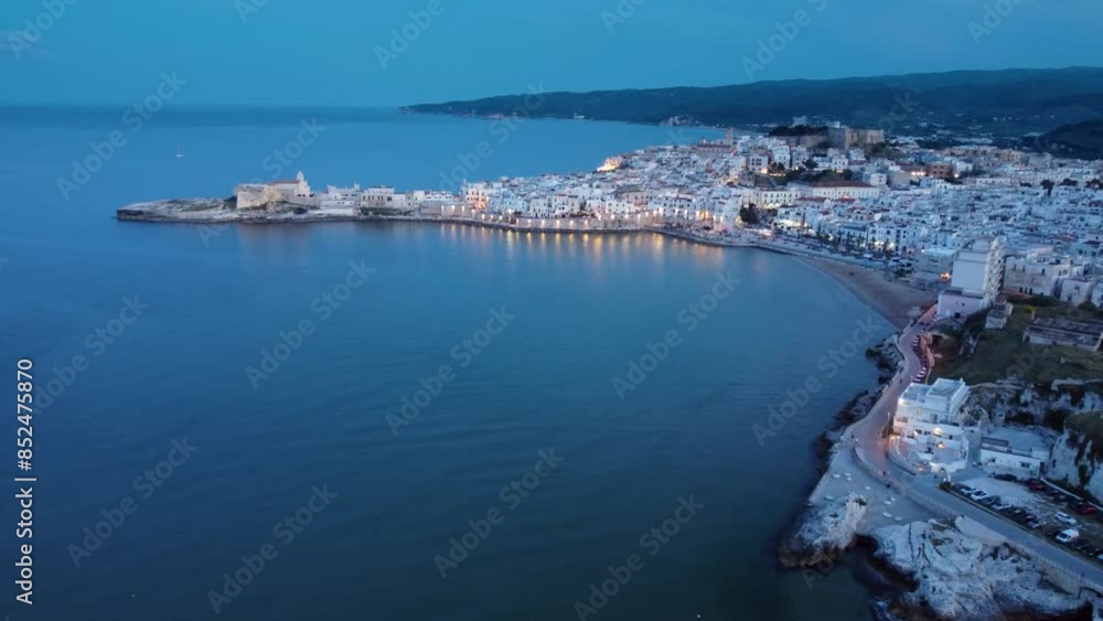 Aerial 4K dusk view of the beautiful seaside town of Vieste, a coastal town in Gargano National Park, in southeast Italy Aerial 4K dusk view of the beautiful seaside town of Vieste, a coastal town in Gargano National Park, in southeast Italy