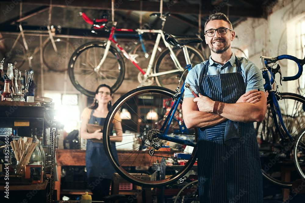 Man, portrait and arms crossed in bicycle repair shop for work in maintenance garage. Bike, mature mechanic and service with professional handyman for startup, small business and workshop for fixing Man, portrait and arms crossed in bicycle repair shop for work in maintenance garage. Bike, mature mechanic and service with professional handyman for startup, small business and workshop for fixing