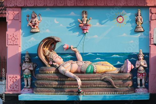 The supreme Hindu god Mahavishnu reclines on the snake Ananta Shesha. Bas-relief on the wall of a Hindu temple in Trivandrum, India. photo