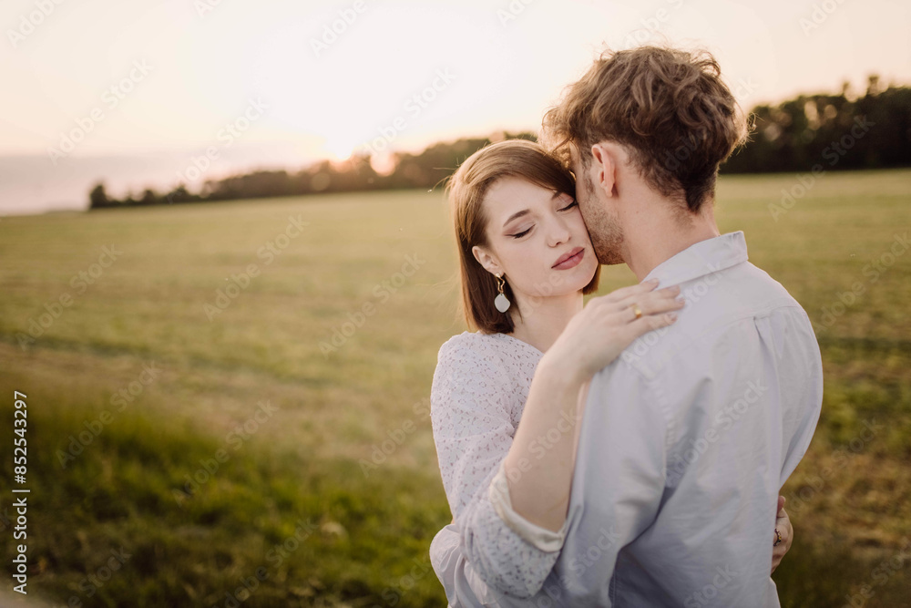 beautiful young couple in a field in the summer on a date in white clothes. beautiful young couple in a field in the summer on a date in white clothes.