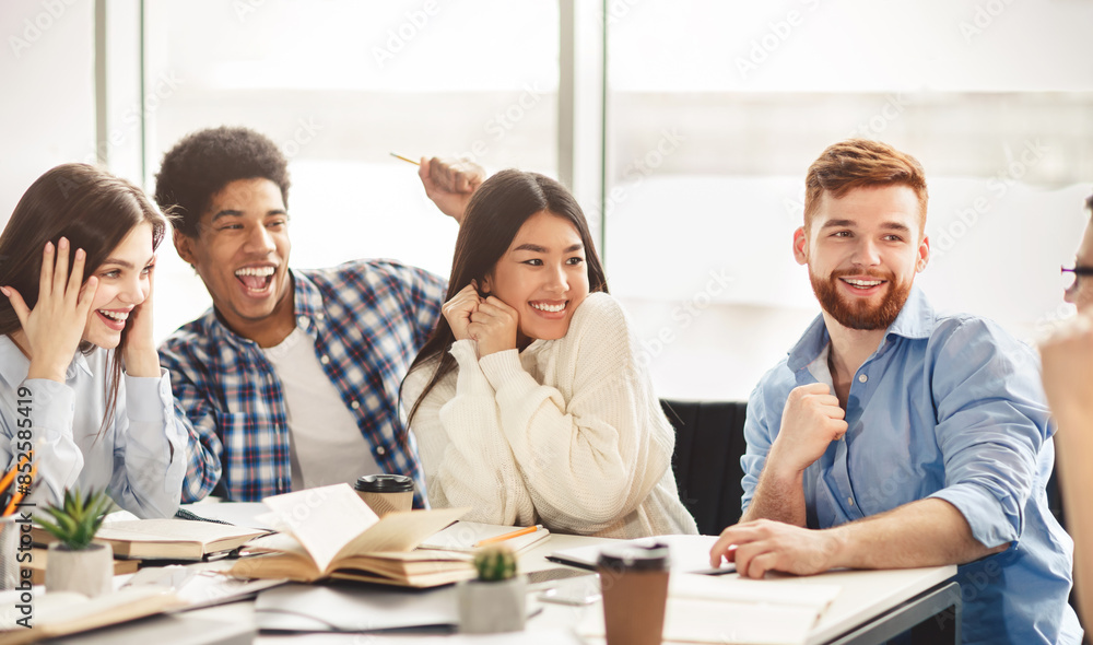 Obraz premium University lifestyle. Happy students talking in college library, telling jokes during break