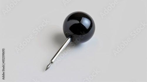 A single black pin with a silver tip resting on a white background © Ева Поликарпова