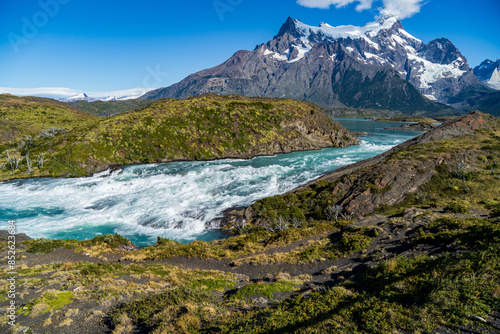 A fast flowing white water turquoise river in front of the Cerro Paine Grande