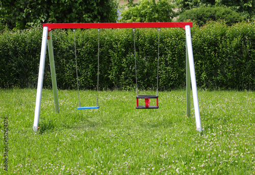 Картината върху платно empty swings in a park with green grass symbolizing the decline in births and de