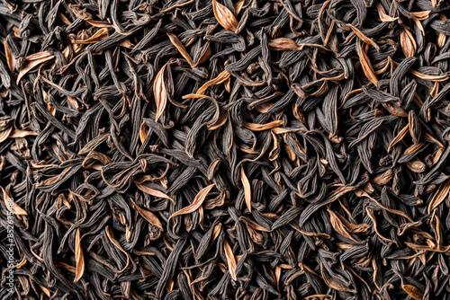 Close-up of black dry tea leaves wallpaper background, texture full frame banner or poster dried tea. Dark abstract food and drink backdrop. Advertising concept. High quality photo. Copy ad text space