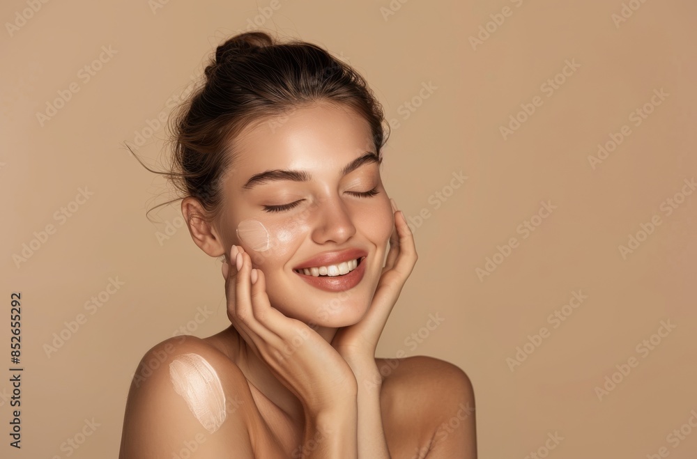 Beautiful woman with smooth, glowing skin touching her face and smiling Beautiful woman with smooth, glowing skin touching her face and smiling