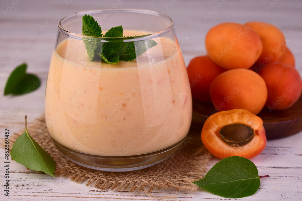 Apricot smoothie in a glass on a white wooden table.Close-up.
Apricot smoothie in a glass on a white wooden table.Close-up.