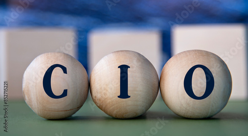 CIO - acronym on wooden balls on the background of wooden large cubes photo